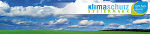 Strahlend blauer Himmel mit weißen Wolken über grüner Landschaft, Symbol für Klimaschutz Steiermark.