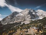 Ansicht eines Berges mit Alm und blauem Himmel